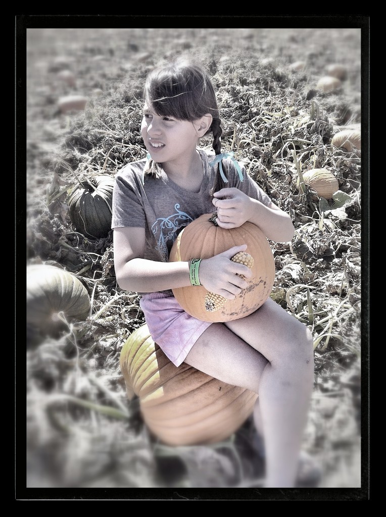 Julie holding her pumpkin while waiting for her brothers to pick their own.
